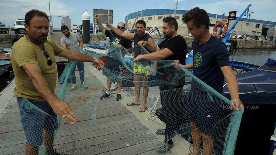 Armadores del &quot;xeito&quot; de Cambados muestran los daños causados por los cetáceos en un paño de pesca. // Iñaki Abella