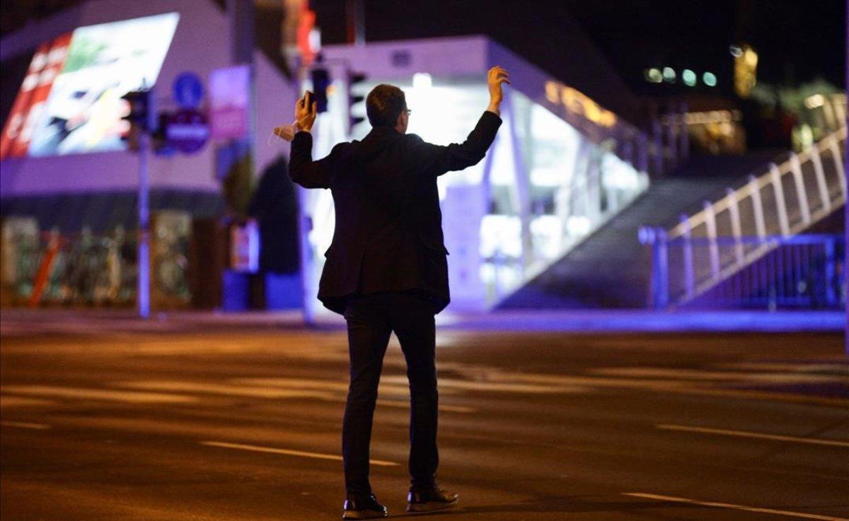 Un hombre levanta las manos a petición de la policía en una calle de Viena, tras el tiroteo.