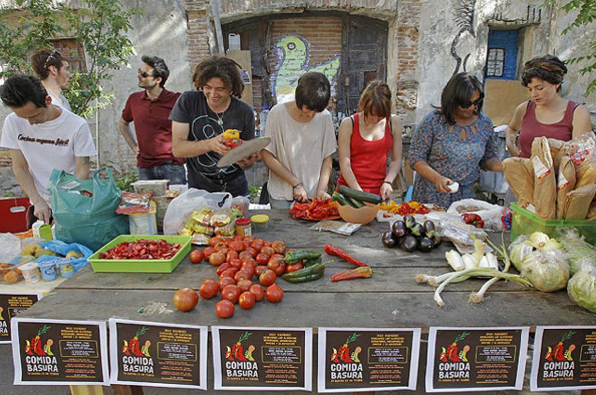 Diversos voluntaris del col·lectiu ’El invernadero de Lavapiés’ preparen els aliments recollits en un contenidor d’escombraries, però en bon estat i precintats, per a un sopar a Madrid al qual estan convidades 100 persones sense recursos.