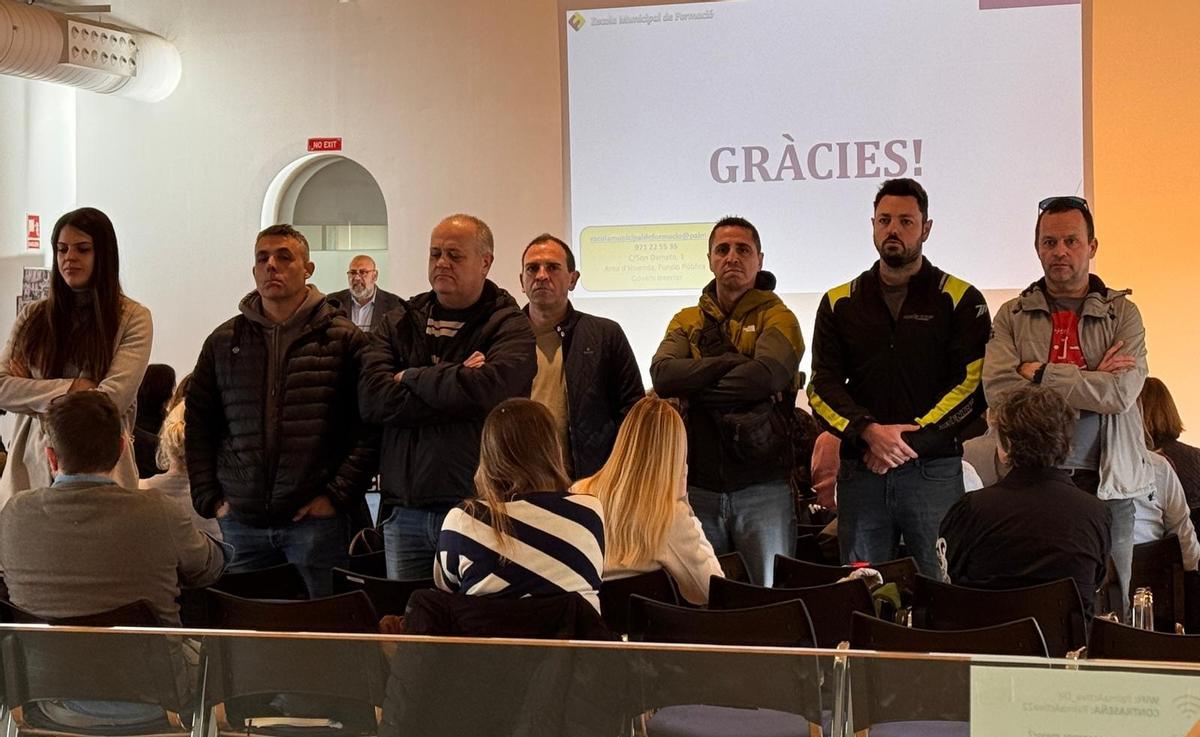 Delegados sindicales dan la espalda al alcalde, al fondo de la imagen.