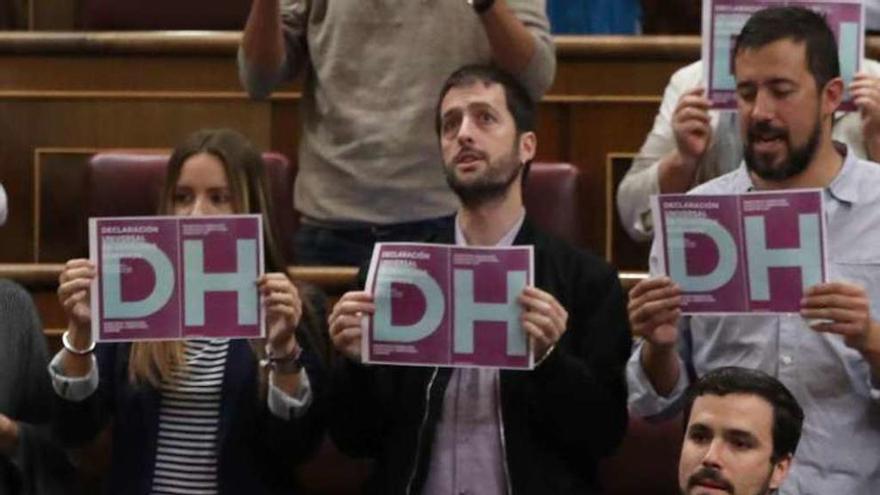 Los diputados de Unidos Podemos, con los carteles. // Efe