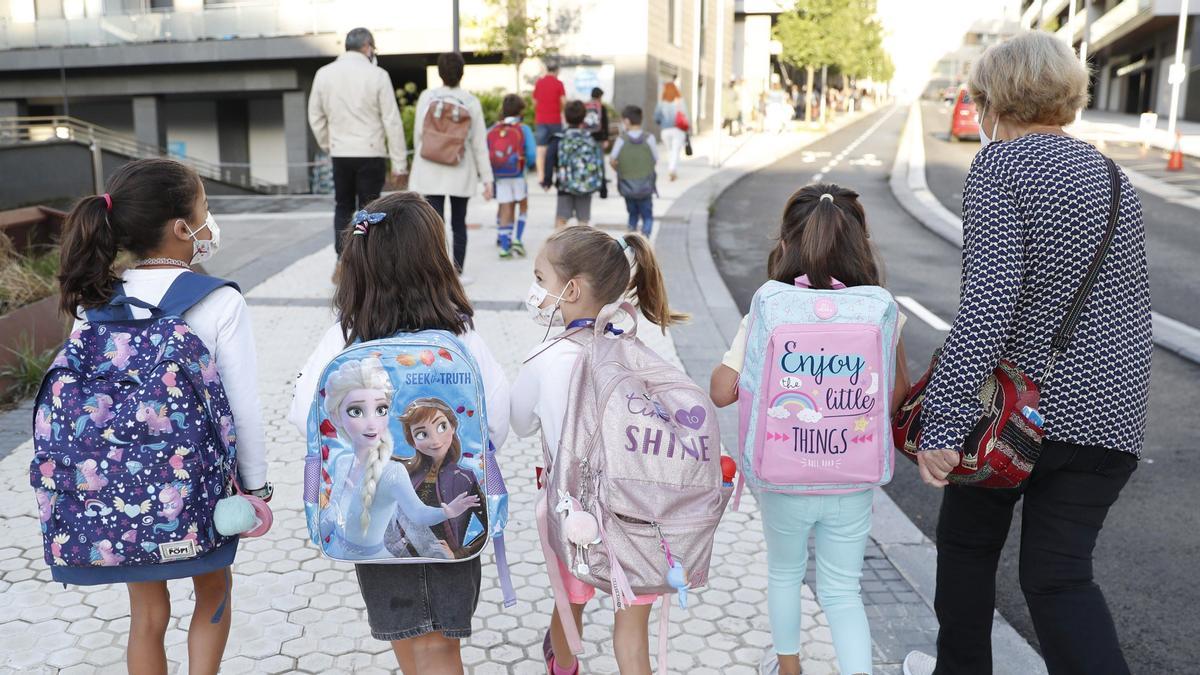 Varias niñas acuden al colegio con mascarilla.