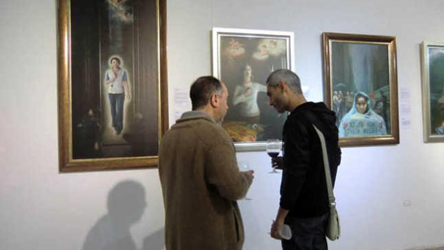 Dos visitantes observan algunas obras de la exposición en el Centro Comercial El Muelle  | lp/dlp