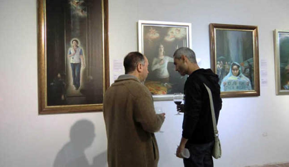 Dos visitantes observan algunas obras de la exposición en el Centro Comercial El Muelle  | lp/dlp