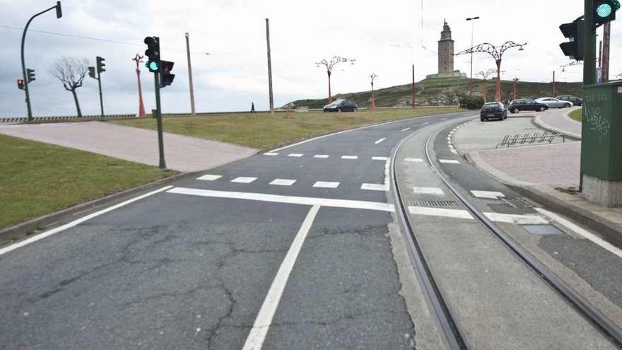 Vías del tranvía turístico a la altura de As Lagoas, con la Torre de Hércules al fondo.