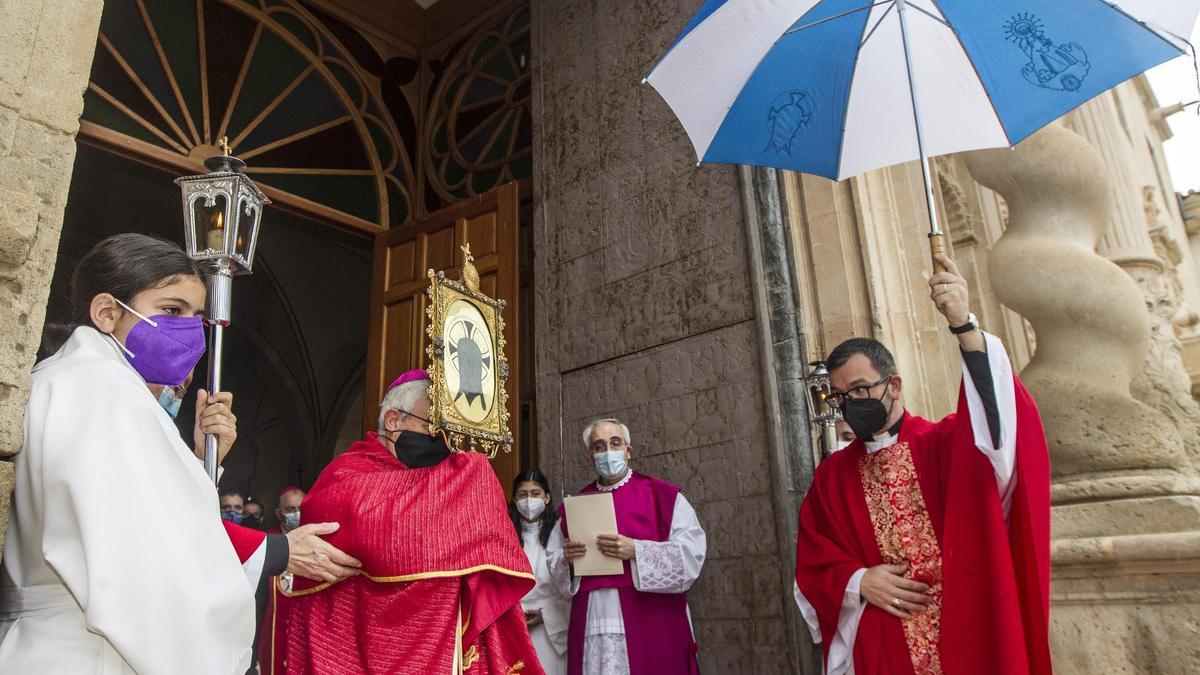 Salida de la Santa Faz ayer, a la puerta del monasterio, para la bendición de la ciudad bajo paraguas