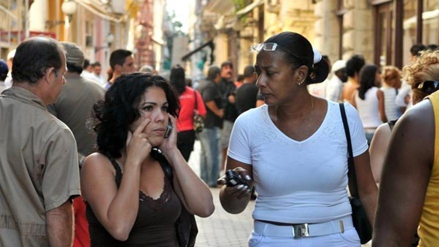 Una mujer camina hablando por un teléfono celular en la Habana  luego de adquirir una línea de telefonía