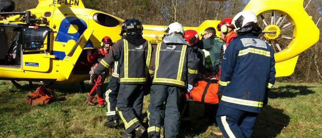 Bomberos y rescatadores trasladan al conductor herido al helicóptero del SEPA.