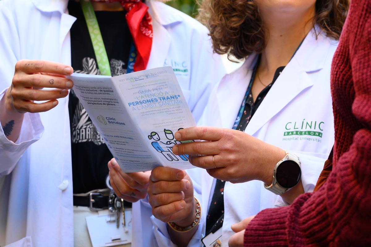Sanitarios sujetan entre sus manos la Guía de Atención a las Personas Trans del Hospital Clínic de Barcelona.