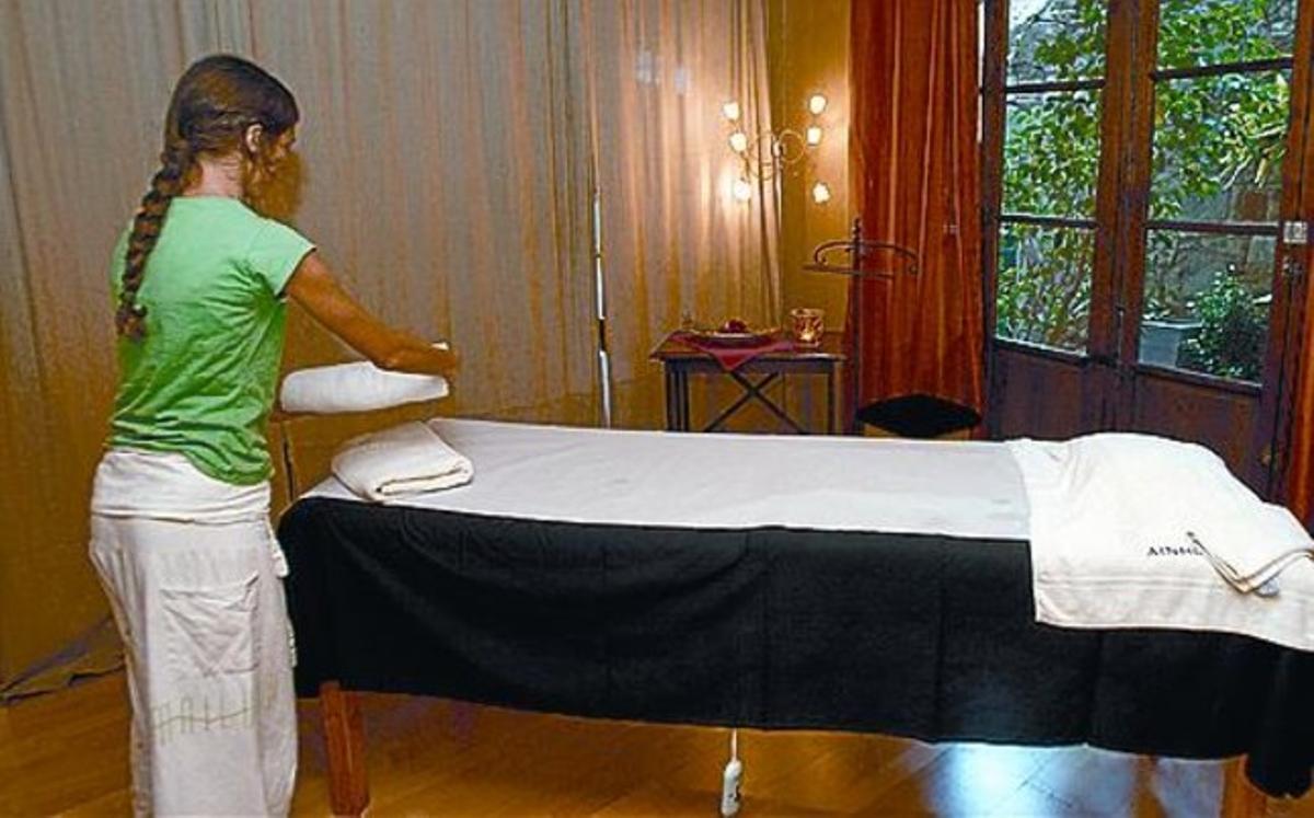 Una de les terapeutes prepara la zona de massatges. Una de les terapeutes prepara la zona de massatges.