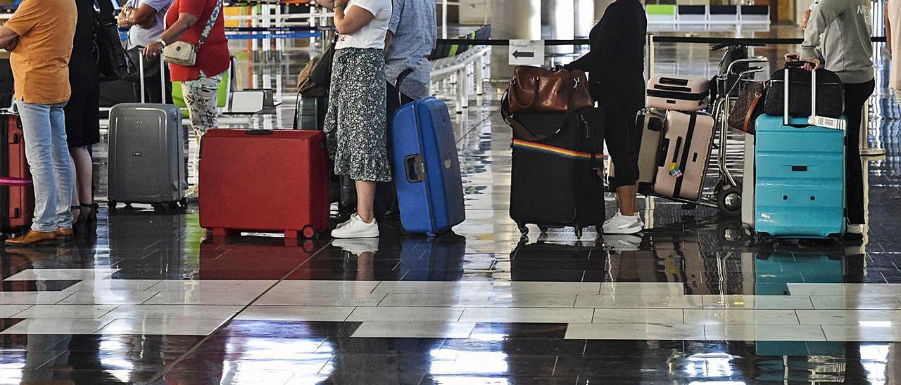 Pasajeros haciendo cola con sus maletas en el Aeropuerto de Gran Canaria durante la huelga del ‘handling’.