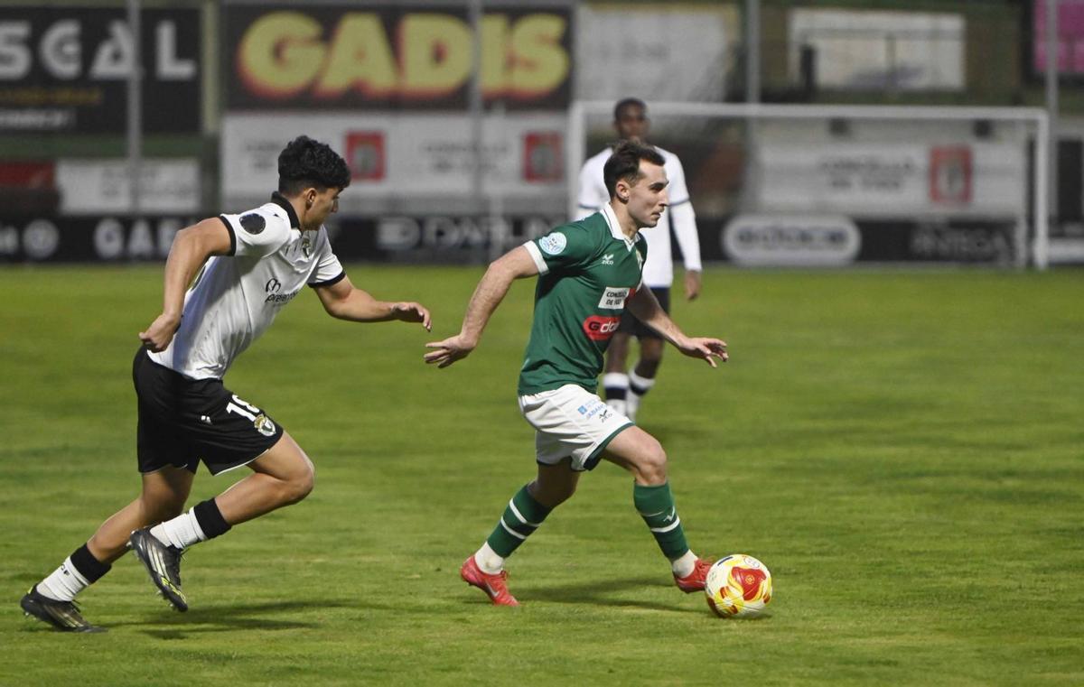 Mateo Gandarillas conduce el balón perseguido por un jugador del Burgos Promesas. | PABLO HERNÁNDEZ GAMARRA