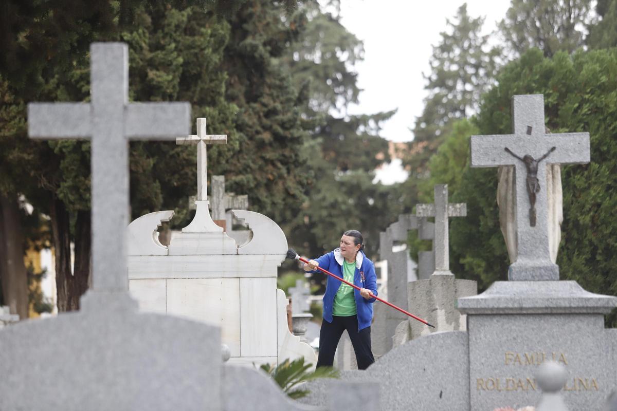 Una mujer limpia un panteón en el cementerio de La Salud.