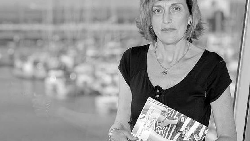 Carmen Menéndez, con su libro, «Mantis», en el puerto deportivo de Gijón.