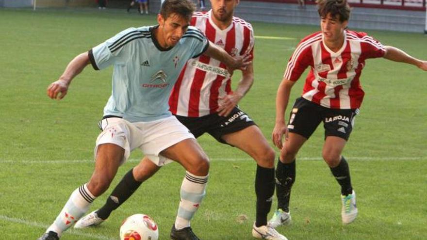 Un jugador del Celta B controla el balón ante la presión de dos rivales de la UD Logroñés, durante el partido de ayer. // La Rioja