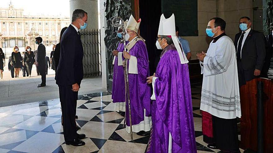 El Rey se detiene a la entrada de la Almudena a saludar al cardenal Osoro.