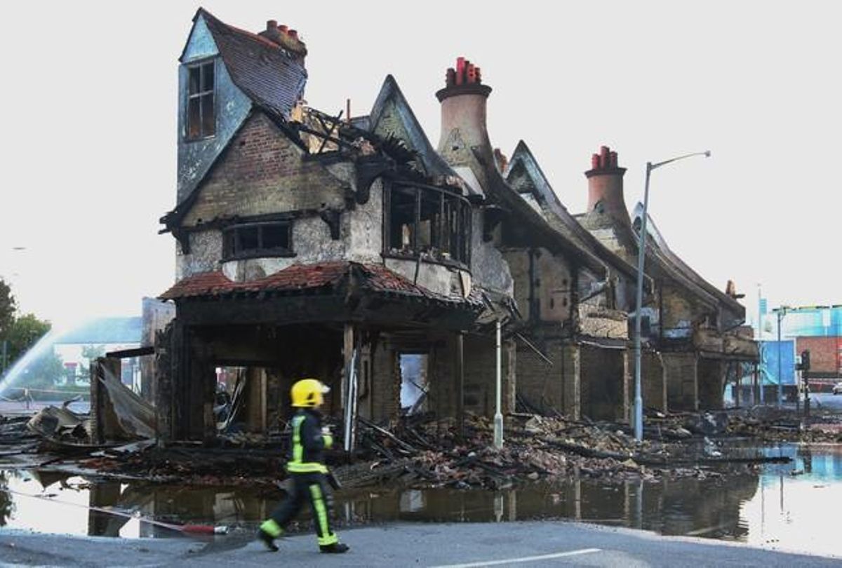 Un bomber vigila les restes de l’incendi en una botiga de mobles durant els disturbis d’ahir a la nit a Croydon, al sud de Londres (Anglaterra).