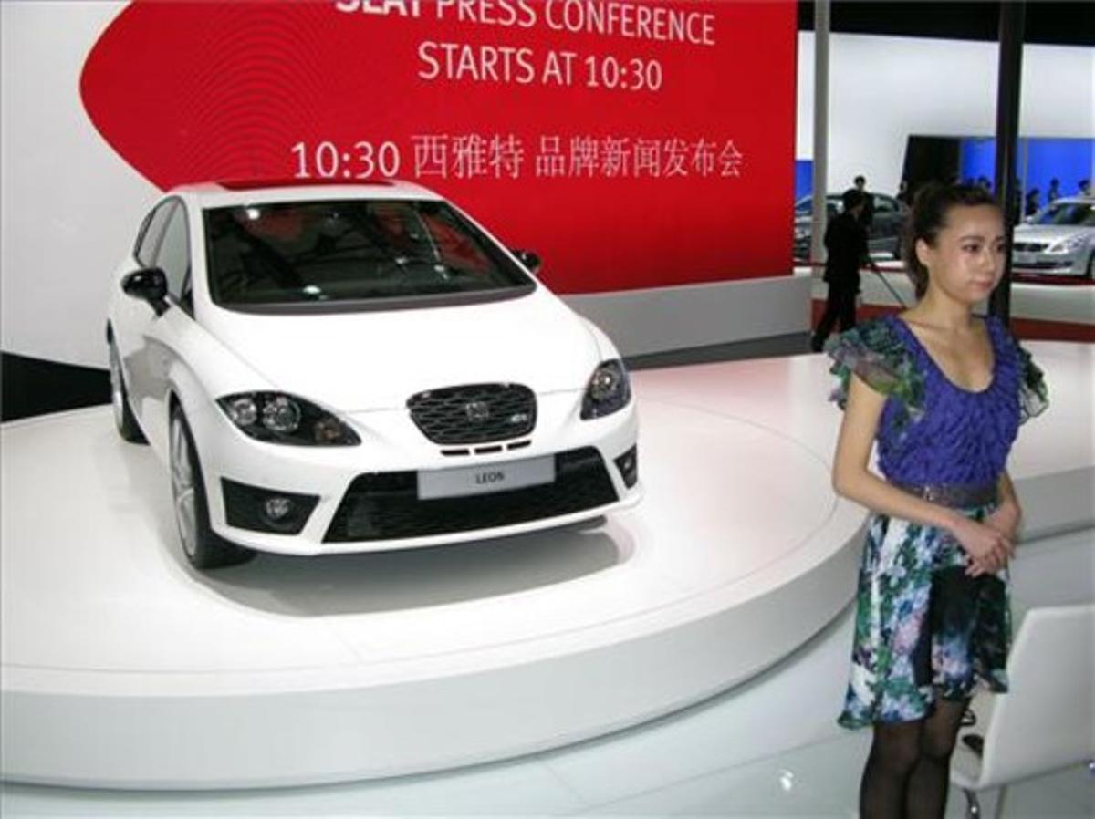 Una hostessa, al costat d’un Seat León exposat a la Fira de l’Automòbil de Xangai. Una hostessa, al costat d’un Seat León exposat a la Fira de l’Automòbil de Xangai.