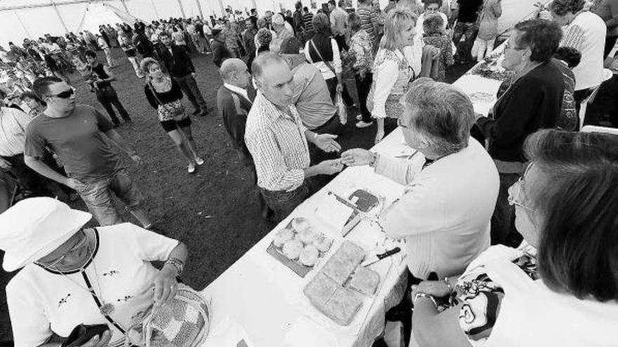 A la izquierda, las elaboradoras de queso casín ofrecen sus productos a los asistentes. A la derecha, cuatro hermanas de Caso, ayer, mostrando su compra en el XXIV Certamen de la Collá d&#039;Arniciu.