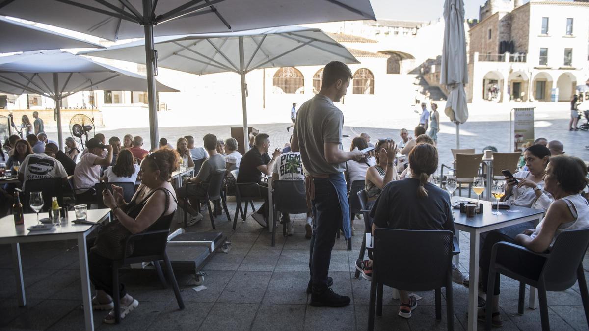 Un camarero atiende en una terraza de la plaza Mayor de Cáceres el pasado verano.