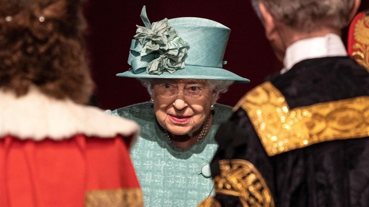 La reina Isabel II habla con unos oficiales antes de pronunciar su discurso, este jueves en Londres.