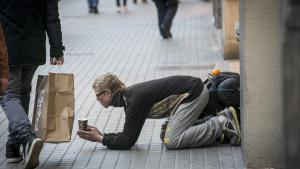 Una persona sin hogar pide dinero en las calles de Barcelona.