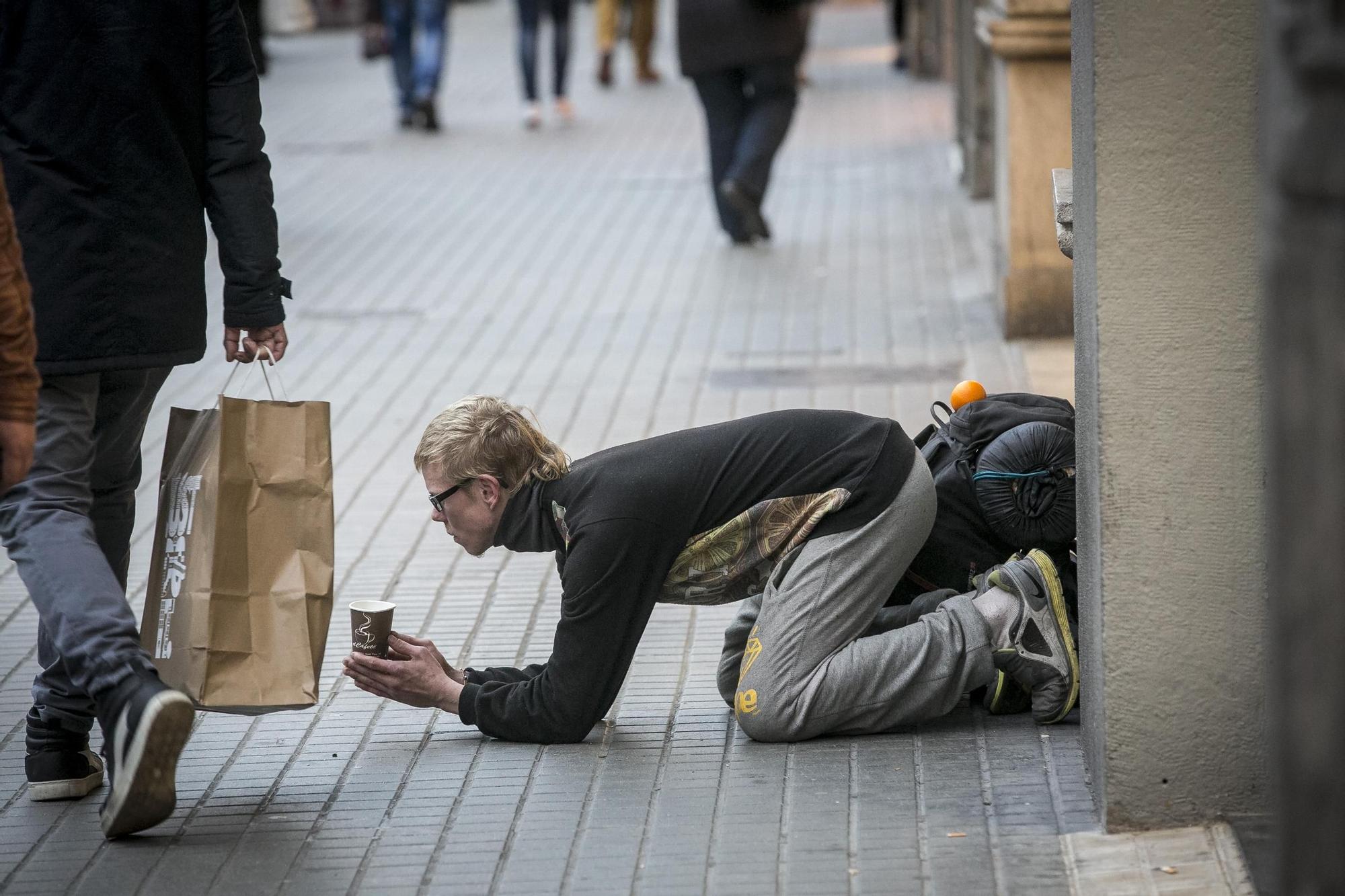 Una persona sin hogar pide dinero en las calles de Barcelona.
