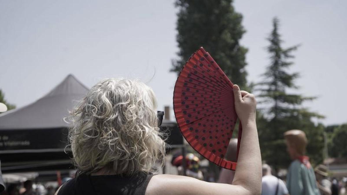 Una dona es venta intentant aguantar la calor durant un acte festiu d'aquest juny a Sant Joan