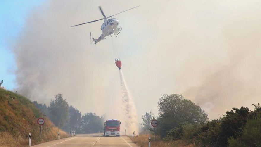 Un helicóptero descarga agua en las proximidades de la N-120, cerrada a su paso por A Cañiza.