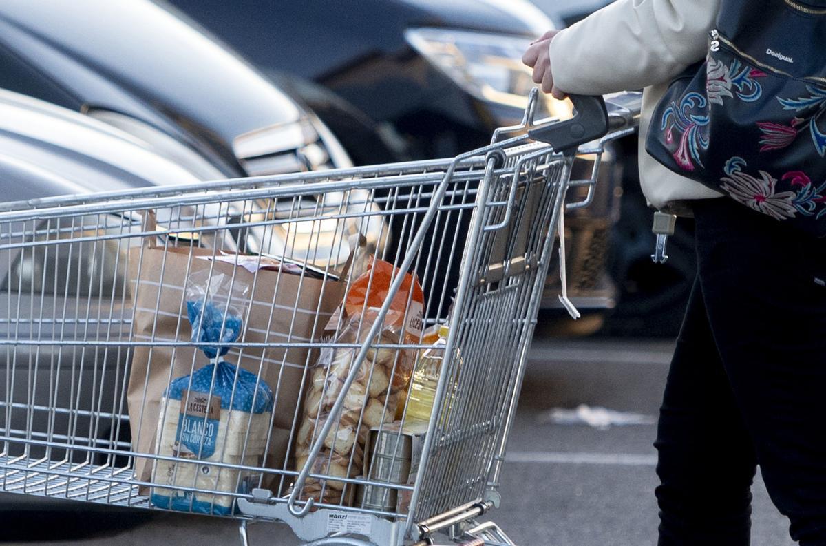 Una mujer sale de supermercado con una carro de la compra, a finales de 2022.