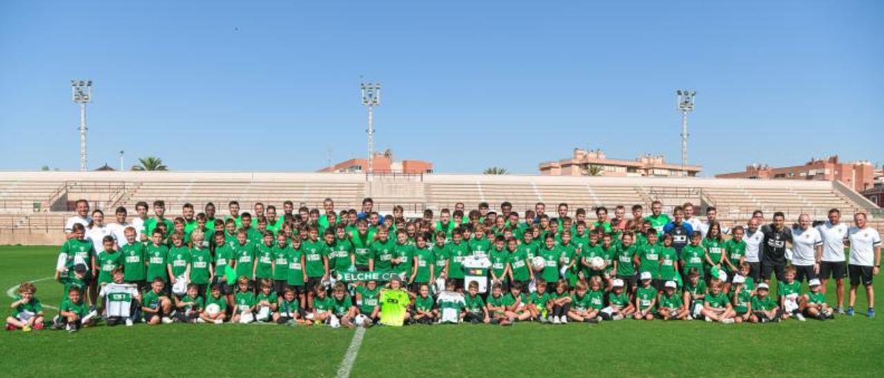 Los alumnos del Campus de Verano del Elche CF han visitado hoy a los jugadores en su entrenamiento en el Díez Iborra y se han hecho una gran foto de familia. | SONIA ARCOS / ECF