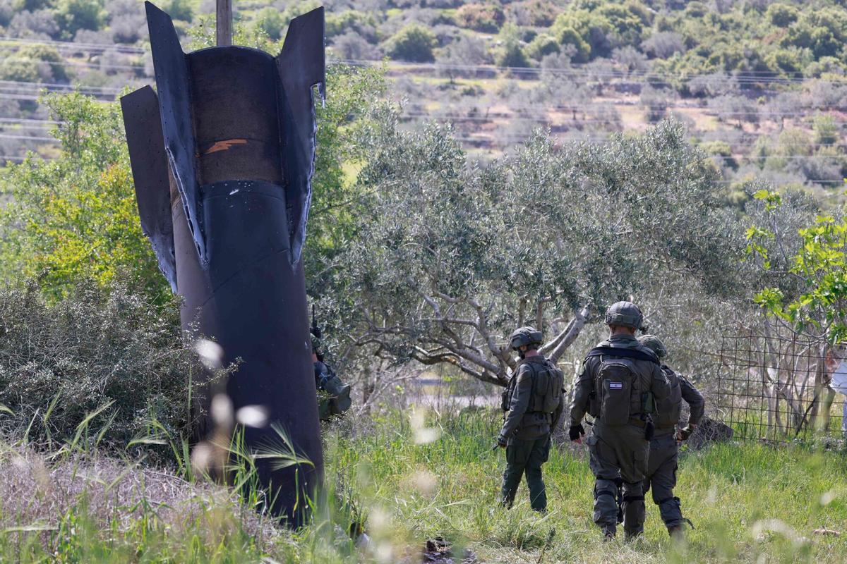 Soldados israelíes inspeccionan un misil iraní incrustado en un campo de de la aldea cisjordana de Hares, este martes.