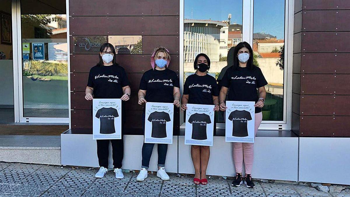 Organizadoras y participantes e la campaña muestran las camisetas que entran a sorteo.