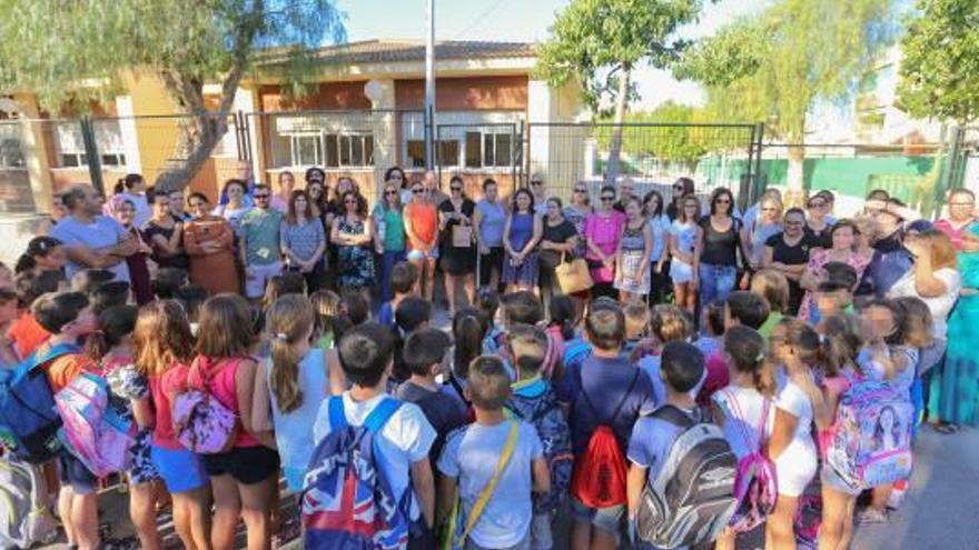 Escolares de tercero de primaria junto a sus padres en el patio.