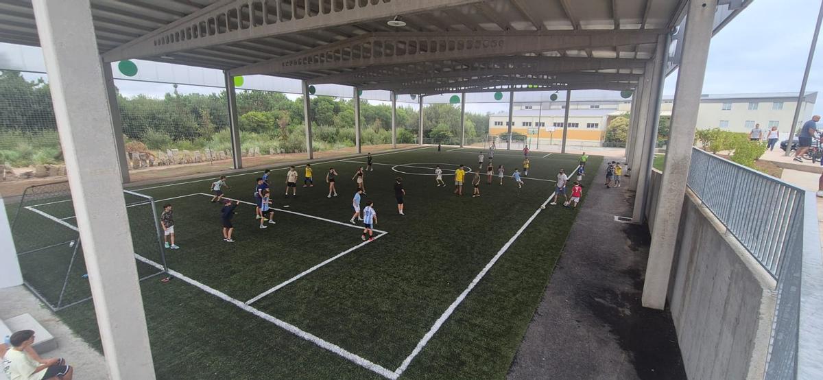 Niños jugando en el campo de fútbol 5.