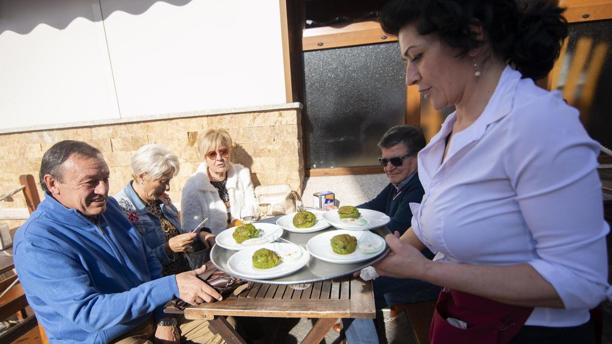 Por la izquierda, Mundo Díaz, Blanca Comonte, Charo Fernández, José María Conde y Milagros Romo, que sirve lospinchos en una terraza de un bar de San Juan de la Arena en una edición anterior.