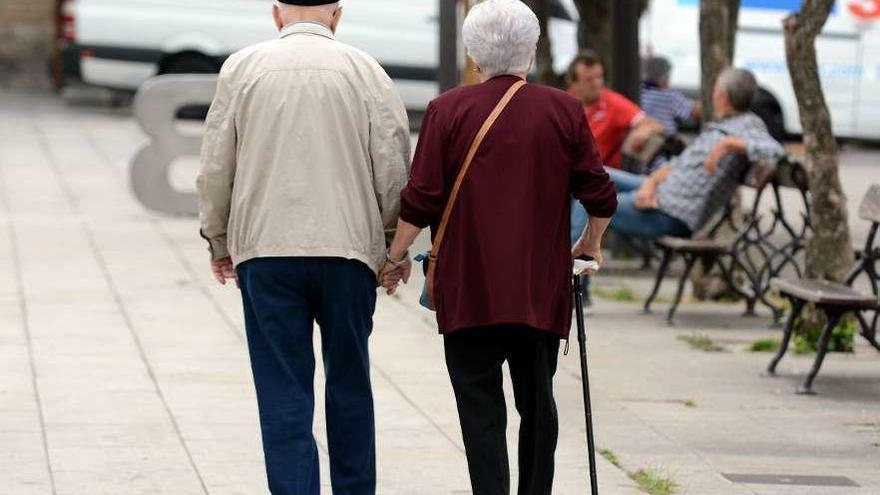 Una pareja de ancianos pasea por una ciudad gallega. // Rafa Vázquez