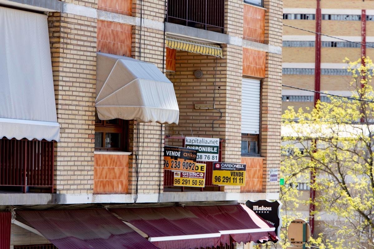 Imagen de archivo de carteles de venta de pisos instalados en un balcón de Ontinyent.