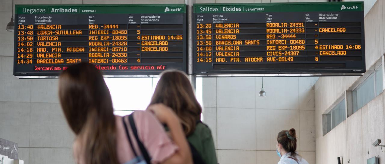 Varias usuarias consultan el panel de información de la estación de Castelló con trenes cancelados durante la huelga de maquinistas de septiembre.