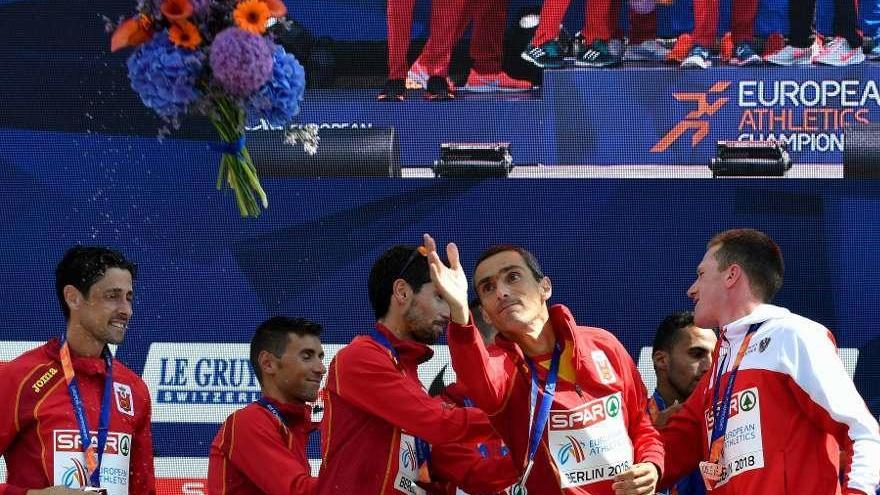 Jesús España lanza el ramo de flores después de recibir la medalla de plata con el equipo español de maratón.