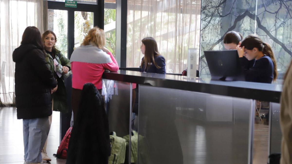 Una recepcionista atiende a huéspedes en un hotel de Córdoba.