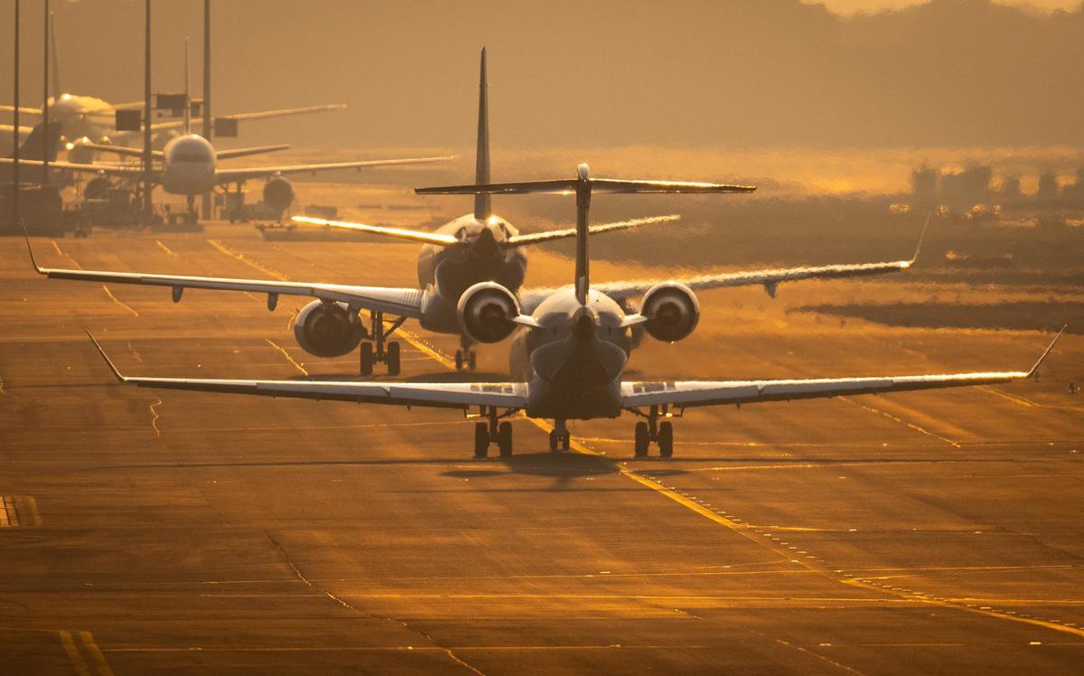 Flugzeuge rollen auf dem Flughafen Frankfurt im letzten Sonnenlicht des Tages über die Rollbahn.
