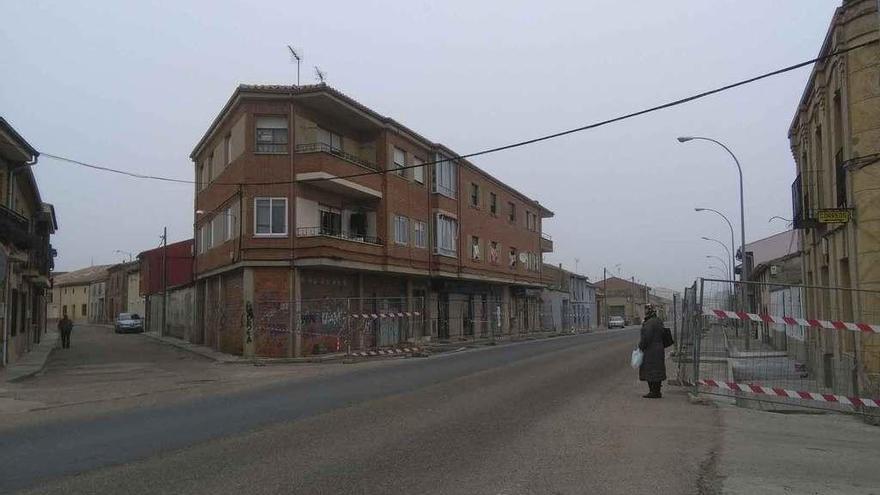 Una mujer espera la llegada del autobús junto a la parada en la que se habilitará la marquesina.