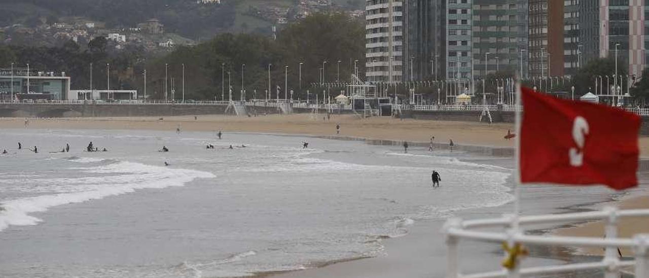 Surfistas en San Lorenzo, con bandera roja, el pasado año.