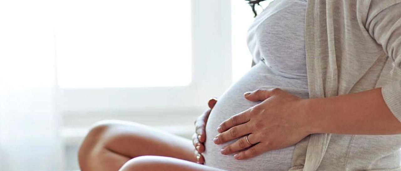 Una mujer embarazada acaricia su vientre. | / SHUTTERSTOCK