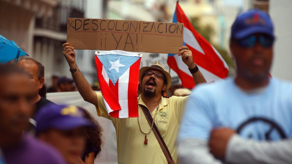 Manifestación de puertorriqueños con motivo del Día del Trabajo y contra la junta de control fiscal, este domingo en San Juan.