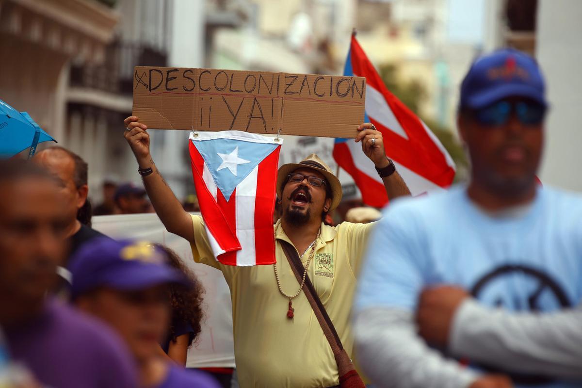 PR01.SAN JUAN (PUERTO RICO), 01/05/2016.- Puertorriqueños marchan hoy, domingo 1 de mayo de 2016, durante una manifestación por el Día Internacional de los Trabajadores en San Juan (Puerto Rico). Los manifestantes rechazan la propuesta de una junta de control fiscal como medida para atender y resolver la llamada crisis fiscal. EFE/THAIS LLORCA