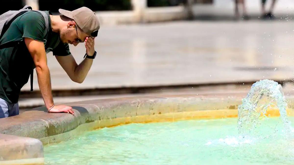 Un joven se refresca contra el calor.