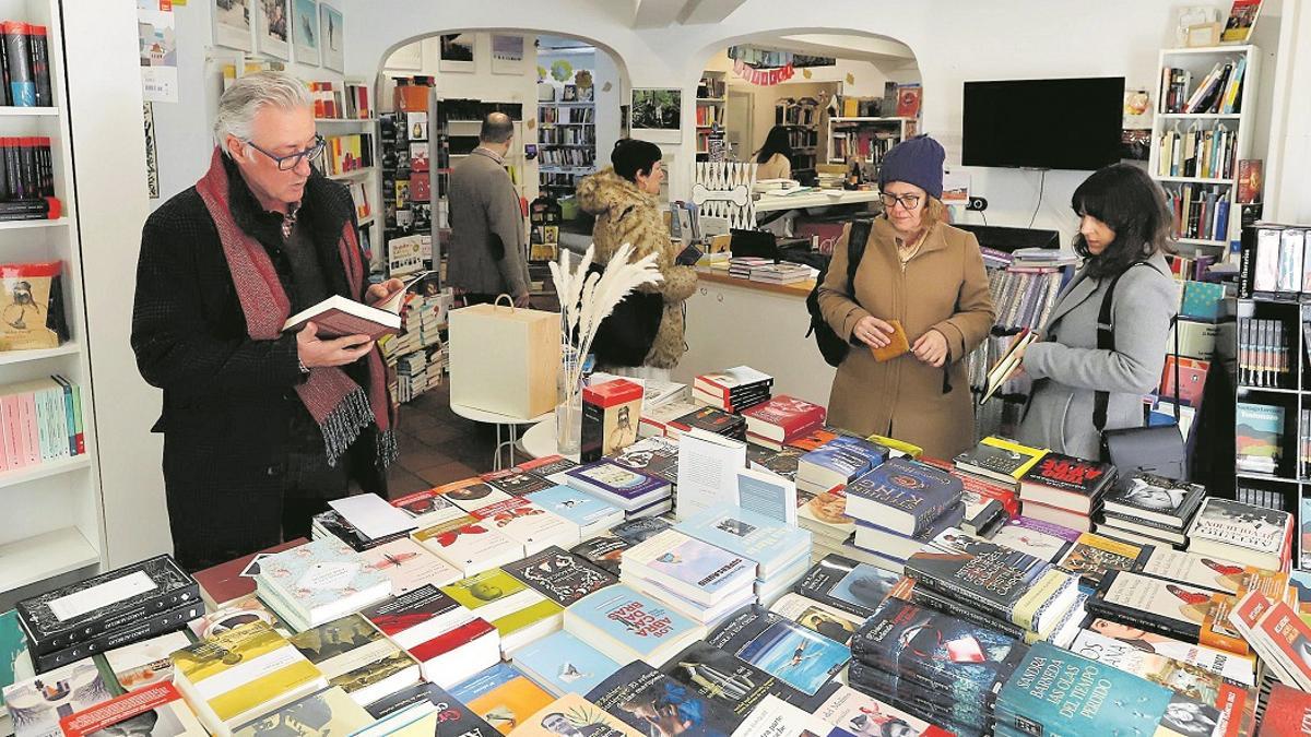 Varios clientes buscan lectura en una librería.