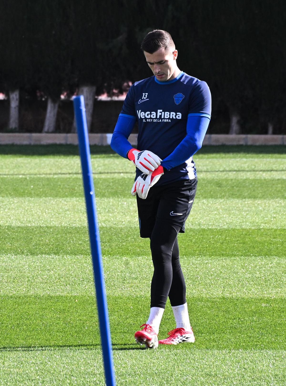 Iñaki Peña se pone los guantes durante un entrenamiento previo al Elche-Barça.